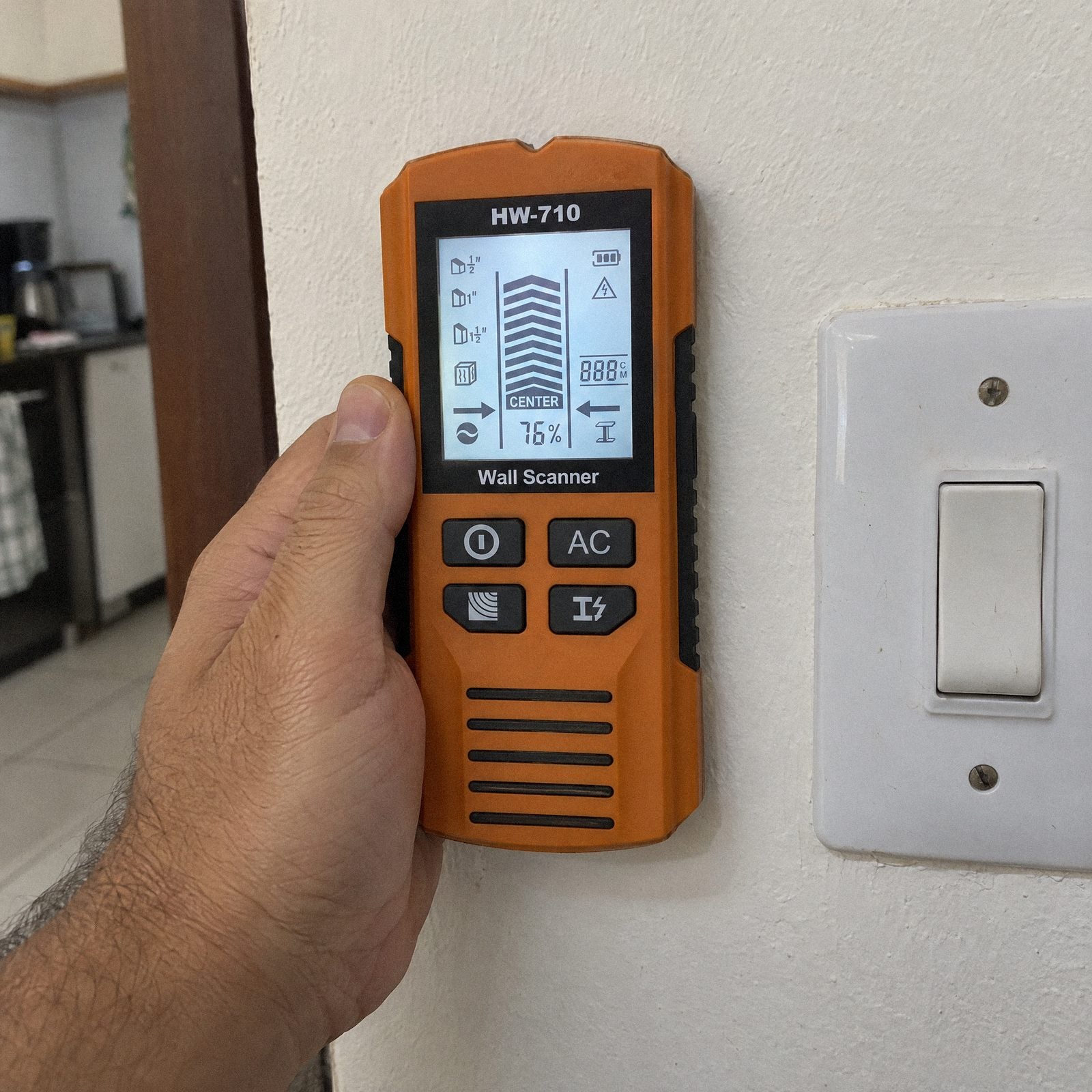 Detector de Parede Carbon encostado na parede ao lado do interruptor
